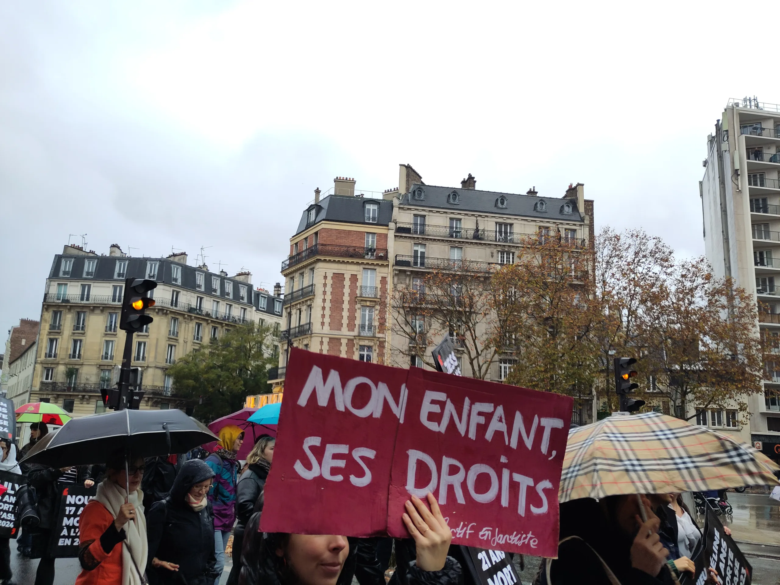 Une photo de manifestation. Une pancarte au centre "Mon enfant, ses droits"